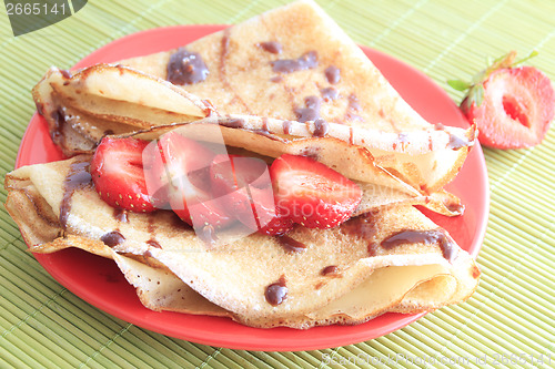 Image of pancakes with strawberries on red plate