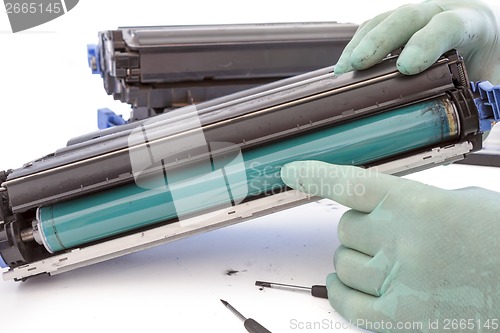 Image of hands repairing toner cartridge