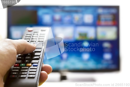 Image of Smart tv and hand pressing remote control
