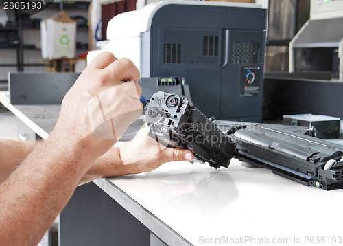 Image of Hands repairing toner cartridge