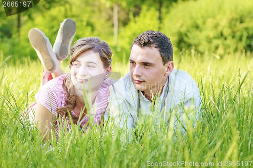 Image of Young couple lying in park