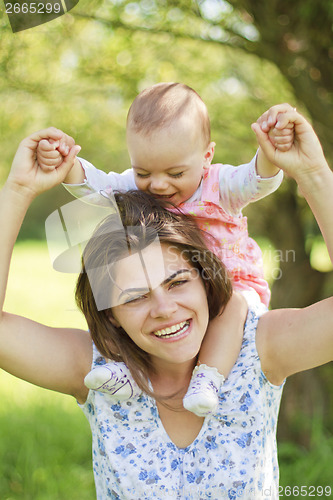Image of happy mother with her child on her shoulders