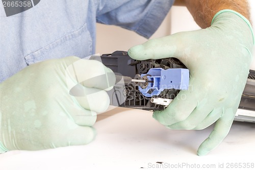 Image of Hands repairing toner cartridge