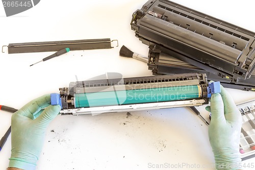 Image of hands repairing toner cartridge