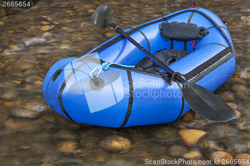 Image of packraft with a paddle