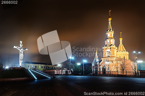 Image of Statue of the crucifixion and church.