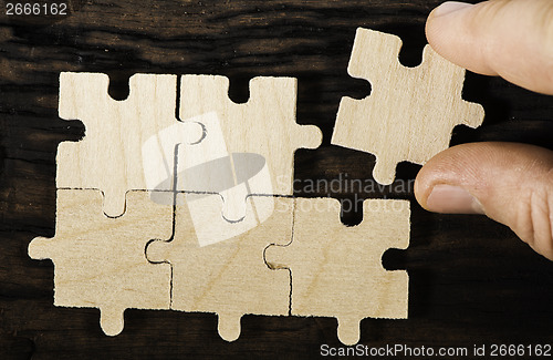 Image of Wooden puzzle on dark background. 