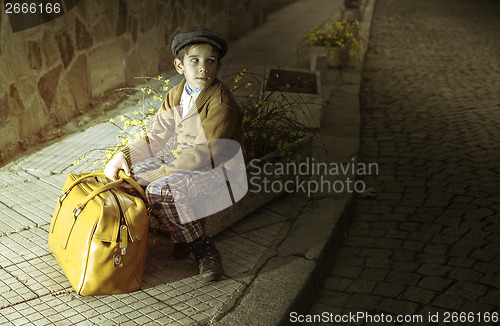 Image of Child on a road with vintage bag