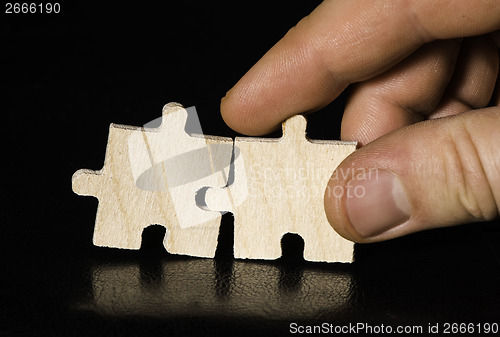 Image of Wooden puzzle on black background. Close up