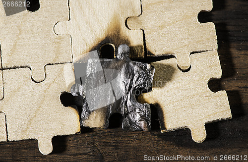 Image of Burning wooden puzzle on dark background.