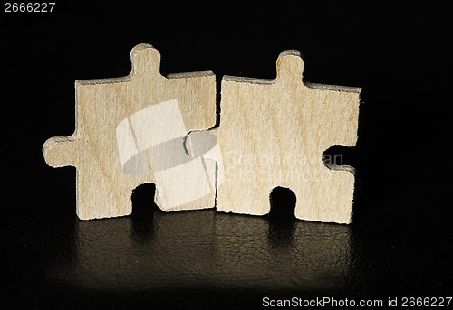 Image of Wooden puzzle on black background