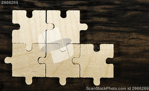 Image of Wooden puzzle on dark background. 