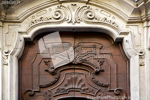 Image of abstract   brass   in a   closed wood door    lugano Switzerland