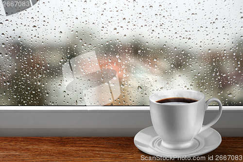 Image of Coffee cup against window with rainy day view