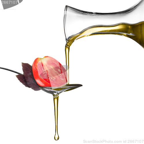 Image of Pouring oil on spoon with basil and tomato isolated on white