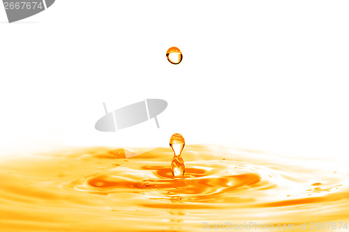 Image of drop falling into orange water with splash isolated on white