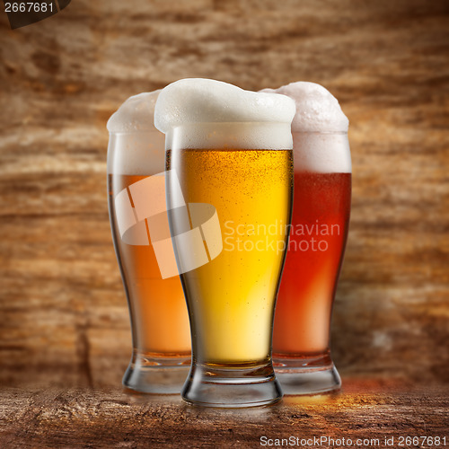 Image of Different beer in glasses on wooden background