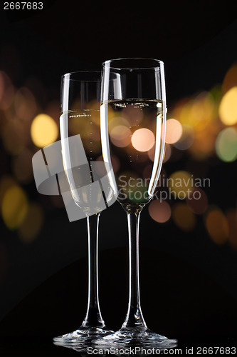 Image of Champagne in glass on black background with color bokeh
