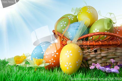 Image of color easter eggs in basket against blue sky and clouds