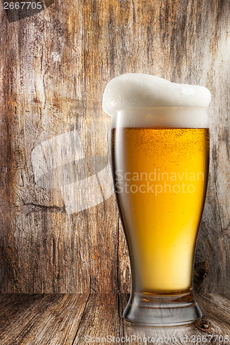 Image of Glass of beer on wooden background