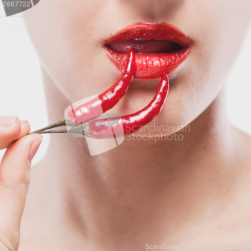 Image of Young woman with chili pepper isolated on white