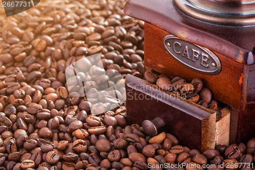 Image of Retro manual coffee mill on roasted coffee beans