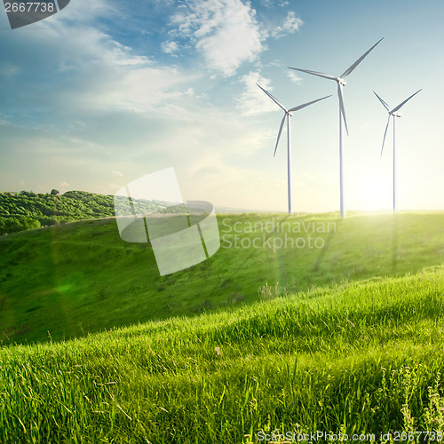 Image of Wind generators turbines on sunset summer landscape