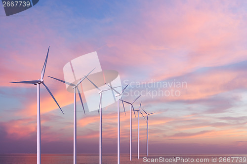 Image of Wind generators turbines in the sea on sunset