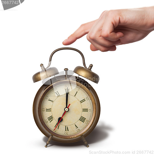 Image of Brown old style alarm clock with hand isolated on white