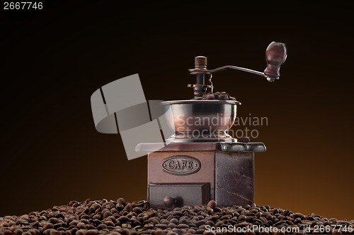 Image of Retro manual coffee mill on roasted coffee beans