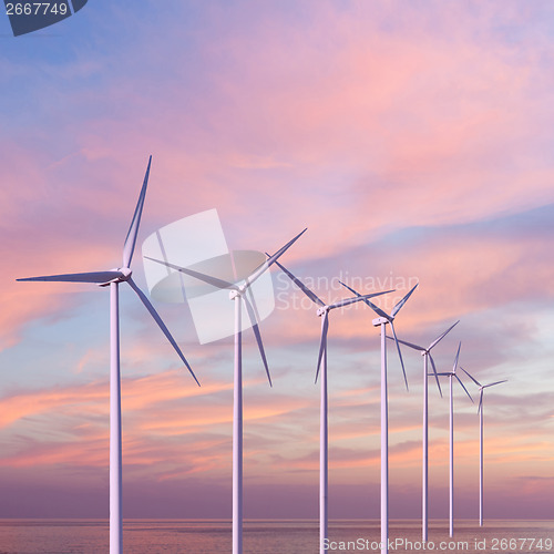 Image of Wind generators turbines in the sea on sunset