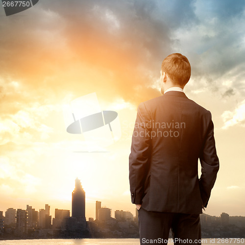 Image of business man look sunrise in the city