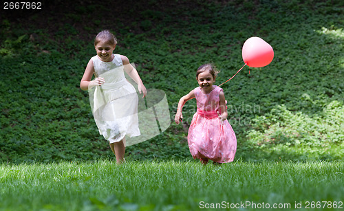 Image of Two little girls running in park