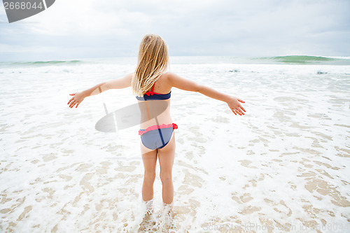 Image of Young girl standing in water at beach