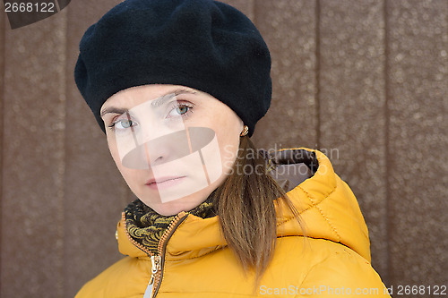 Image of Woman in black beret and yellow jacket