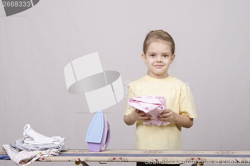 Image of the girl finished ironed clothes iron