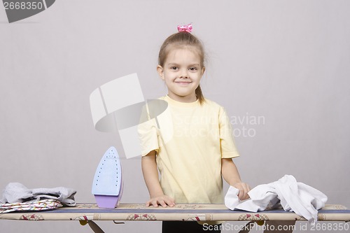 Image of the girl starts to iron