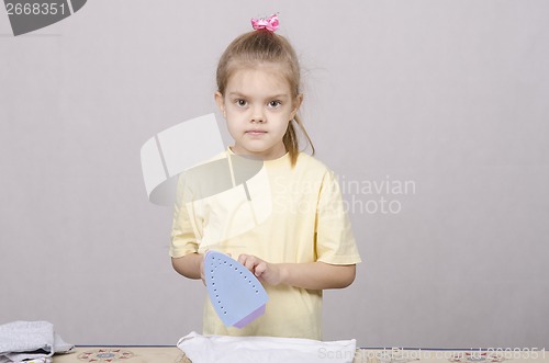 Image of the girl standing near Ironing Board