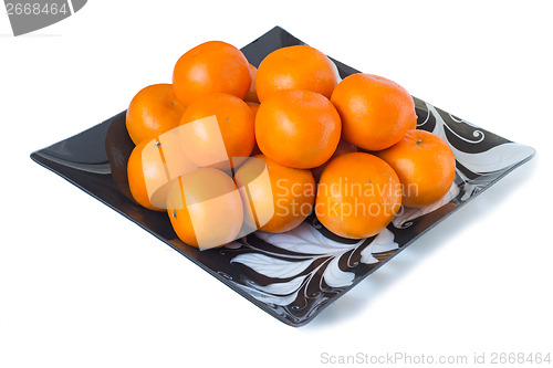 Image of Large ripe tangerines in a glass dish on a white background.