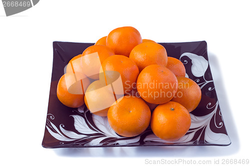 Image of Large ripe tangerines in a glass dish on a white background.