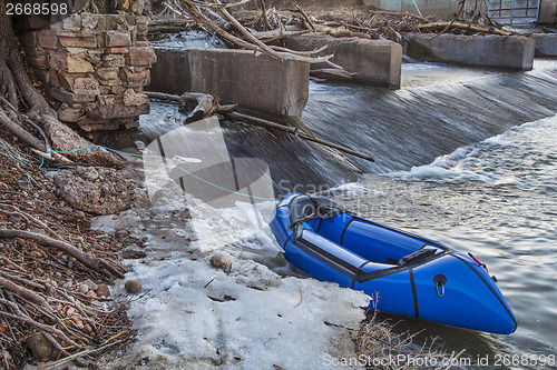 Image of packraft and river dam