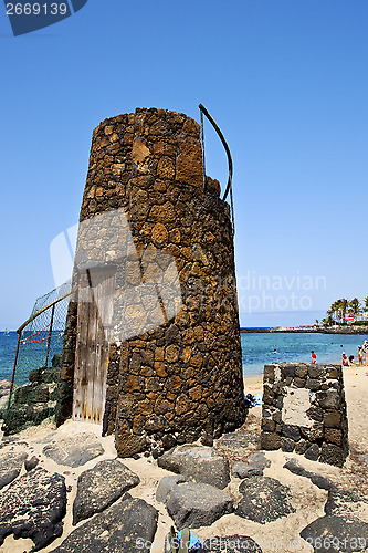 Image of tower  yellow  beach    black rocks in the   lanzarote 