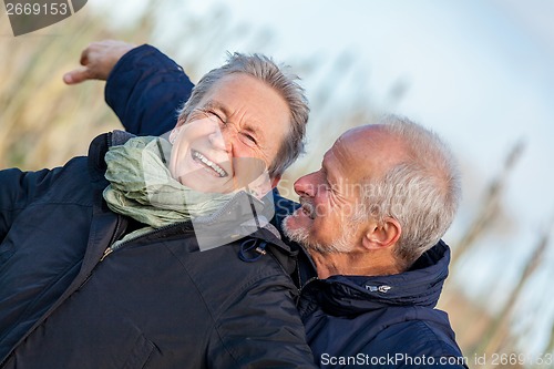 Image of Elderly couple embracing and celebrating the sun