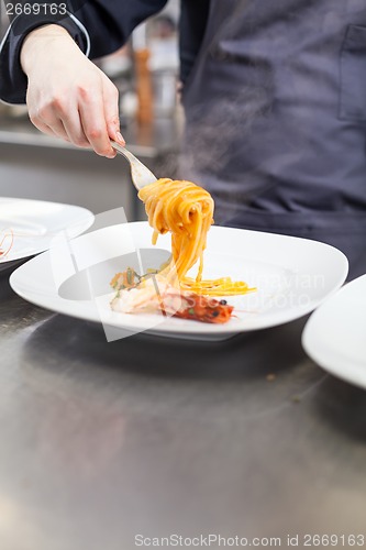 Image of Chef plating up seafood pasta