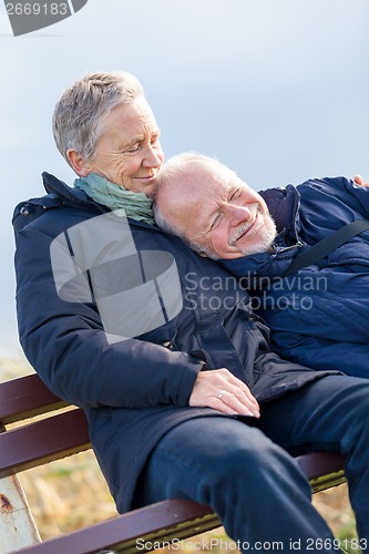 Image of happy senior couple relaxing together in the sunshine