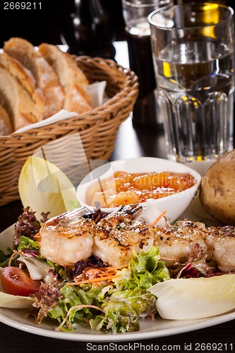 Image of Grilled prawns with endive salad and jacket potato