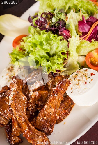 Image of grilled beef stripes fresh salad and goat cheese