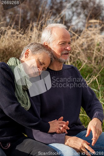 Image of happy senior couple relaxing together in the sunshine