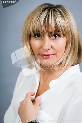 Image of Smiling confident middle-aged blond woman