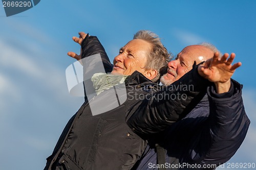 Image of Elderly couple embracing and celebrating the sun